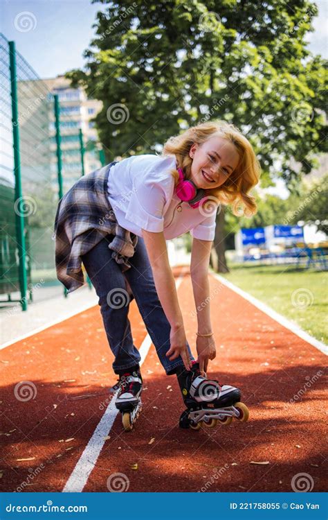 Pretty Teenage Girl Wearing Roller Skaters On The Road In Summe Park