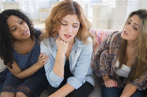 Women Comforting Sad Friend On Sofa In Living Room Photo12 Tetra