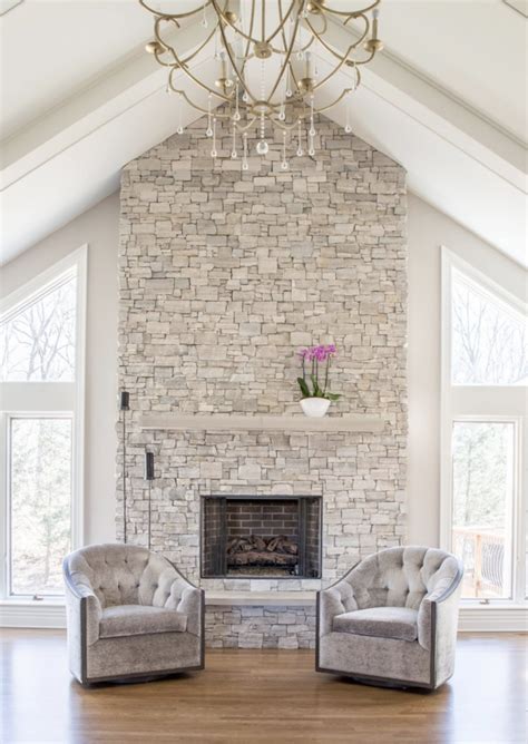 Rustic brick fireplace with a tv in a master bedroom mounted above a blond wood mantel shelf facing a cream cottage living room features a white stone fireplace with a gray wash wooden mantel displaying a wall mount tv overhead. 11 Stone Veneer Fireplace Surround Design Trends & Where ...