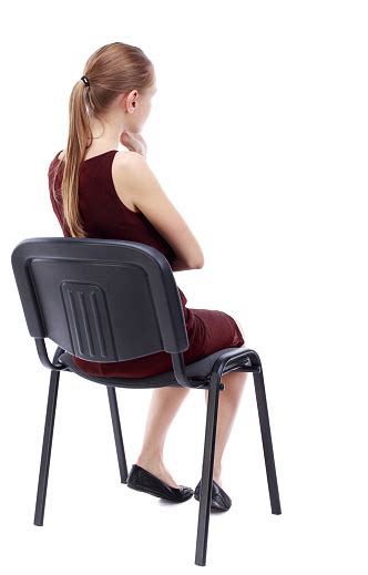 Back View Of Young Beautiful Woman Sitting On Chair Stock Photo