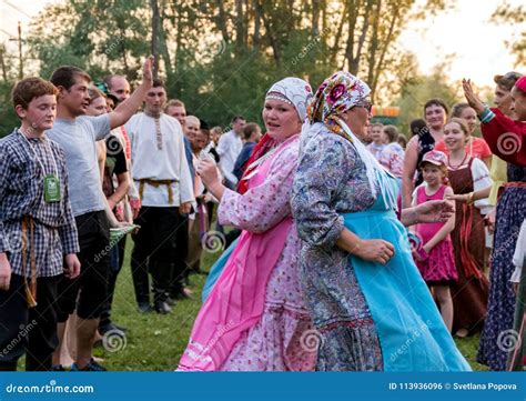 Two Women In Colorful Russian Costumes Dancing For The Time Of The