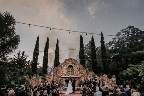An Outdoor Ceremony With People Standing In Front Of It And Fireworks