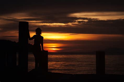 Silhouette Of Woman On Dock During Orange Sunset Hd Wallpaper Peakpx