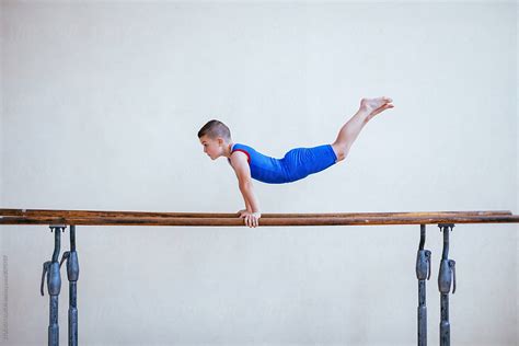 Gymnastics Young Boy Practicing On Parallel Bars By Stocksy