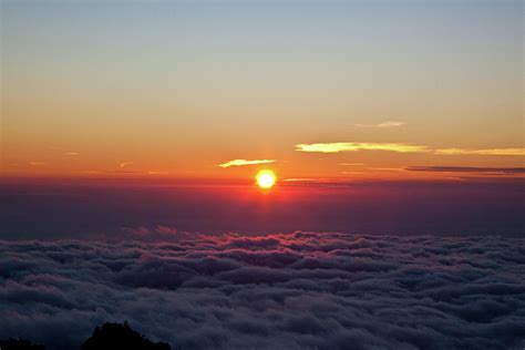 Rising Sun Above The Clouds By Tom Bonaventure