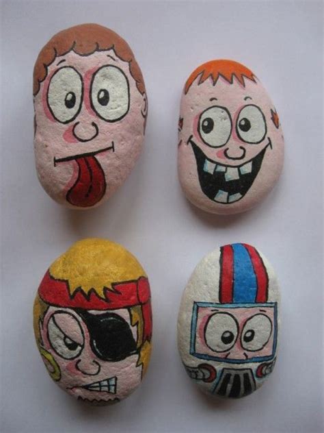 Four Painted Rocks With Cartoon Faces On Them