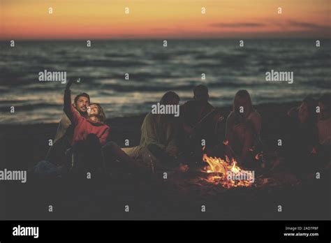 A Group Of Friends Enjoying Bonfire On Beach Stock Photo Alamy