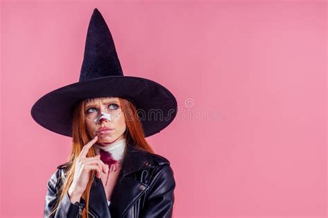 redhaired ginger woman witch black hat and in leather jacket take thought and scaring with crazy