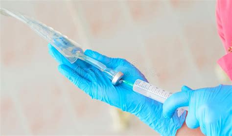 Nurse Holding A Medical Syringe And Solution For Dropper In Hands And