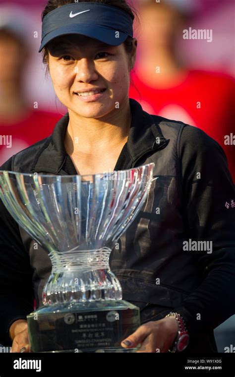 Chinese Tennis Player Li Na Shows Her Trophy After She Won The Champion
