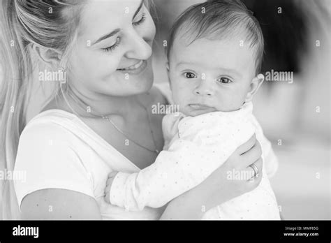 Retrato En Blanco Y Negro De La Madre Sonríe Feliz Abrazando A Su Bebé