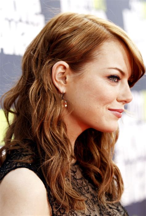 A Close Up Of A Person With Long Hair And Wearing Earrings On The Red