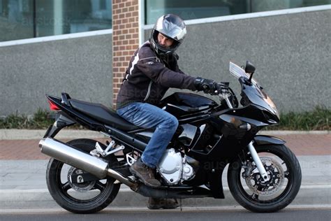 Image Of Man Riding Motorbike On A Suburban Street Austockphoto