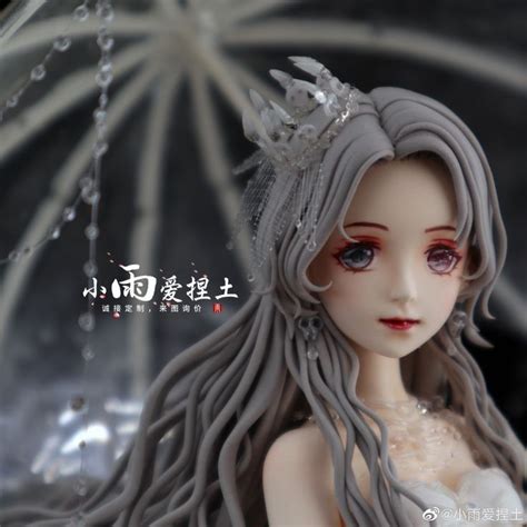 A Close Up Of A Doll With An Umbrella In The Background