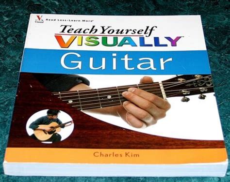 Teach Yourself Visually Guitar Book On Green Carpet With Hand Holding