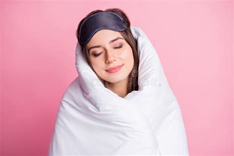 photo portrait of sleeping woman wrapped in bed sheets isolated on pastel pink colored