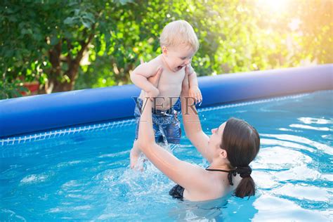 快乐的年轻母亲和她的小儿子，在室外游泳池玩得很开心照片摄影图片 id 162994203 veer图库