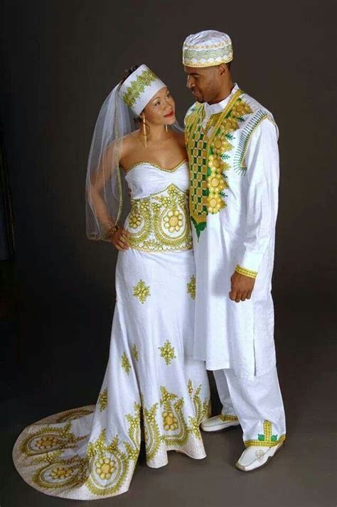 A Man And Woman Dressed In Traditional African Clothing