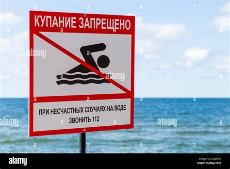 No Swimming Sign With Russian Text Mounted On A Sea Coast Stock Photo