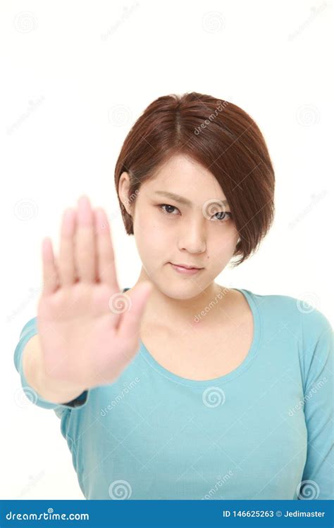 mujer japonesa joven que hace gesto de la parada imagen de archivo imagen de azul persona