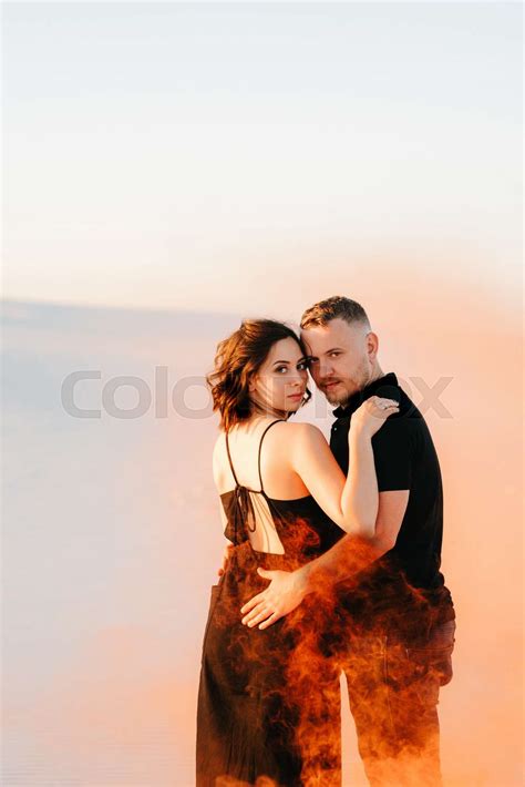 Guy And A Girl In Black Clothes Hug And Run On The White Sand Stock Image Colourbox