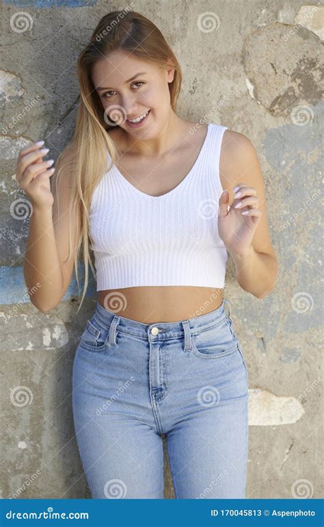 Stunning Young Latina Woman Poses In White Tank Top And Denim Desert