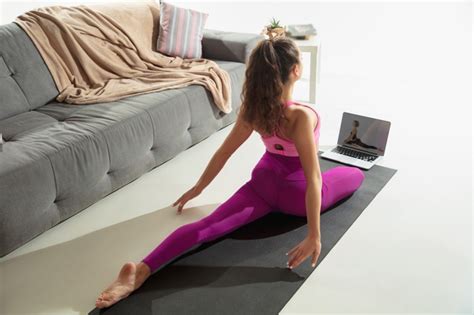 Übe yoga auch auf reisen. Inspiriert. schöne junge frau, die drinnen arbeitet, yoga ...
