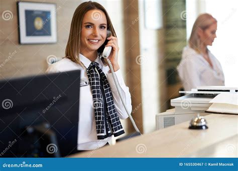 Receptionist Answering Phone At Hotel Front Desk Stock Image Image Of