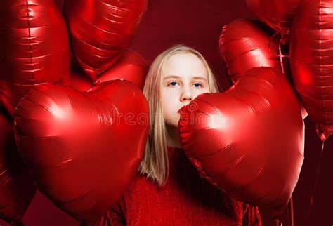 Jeune Fille Blonde Avec Le Coeur Rouge De Ballons Sur Le Fond Rouge
