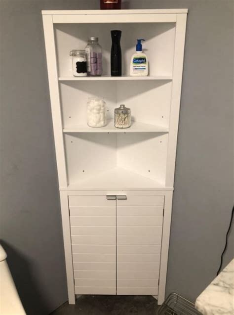 A Bathroom With A Toilet And Shelves In It