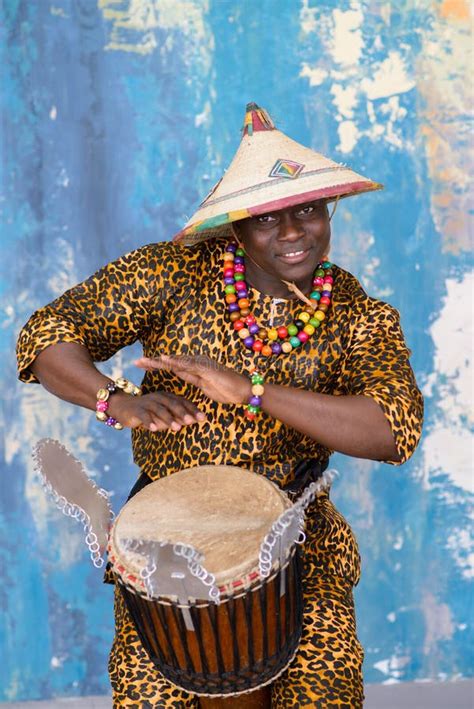 Handsome African Drummer Weared In Traditional Costume Playing On Djembe Drum Stock Image