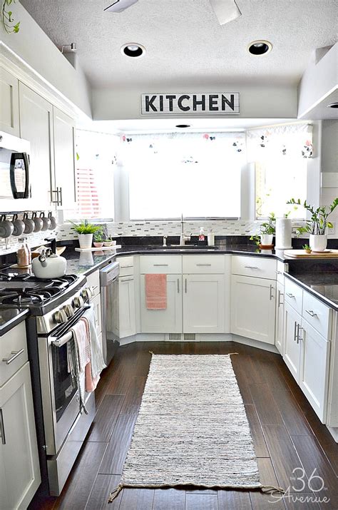 Vicki bodine example of a large country medium tone wood floor kitchen design in new york with a farmhouse sink, beaded inset cabinets, white cabinets, marble countertops, white backsplash, stone slab backsplash, stainless steel appliances and an island White Kitchen - Pink Kitchen Decor | The 36th AVENUE