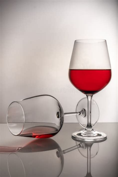 Two Red Wine Glasses On A White Background One Glass Half Full The
