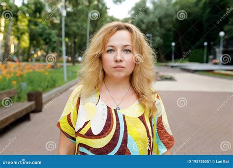 Young Caucasian Plump Lady Standing In Park And Watch At Camera Sad