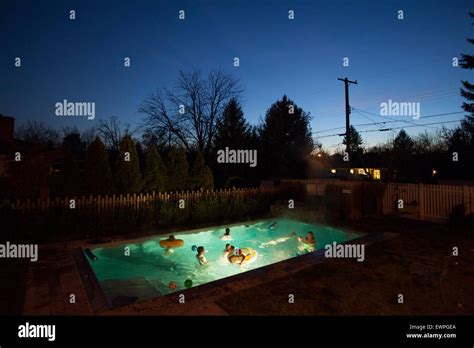 A Lit Up Swimming Pool Full Of People At Night Stock Photo Alamy