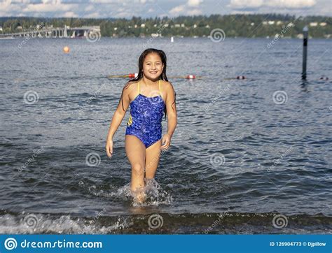 ten year old amerasian girl having fun in the lake at greenlake park seattle washington stock