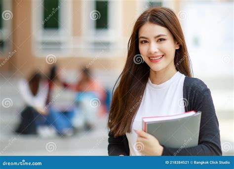 Young And Beautiful Asian College Student Girls Holding Books Pose To