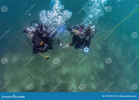 Master Diver And Dive Pupil Preparing To Ascend After Dive Training At