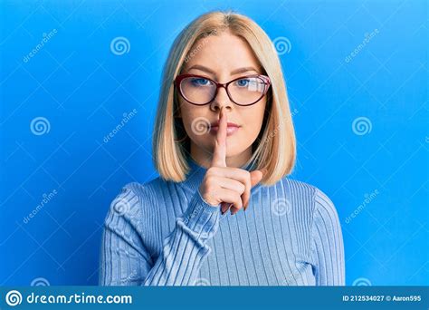 Young Blonde Woman Wearing Casual Clothes And Glasses Asking To Be Quiet With Finger On Lips