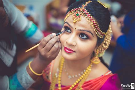 beautiful traditional indian bride getting ready for her wedding day by makeup artistbeautiful