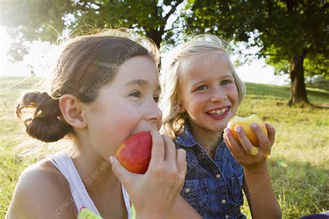 Laughing Girls Eating Apples Outdoors Stock Image F0065078 Science Photo Library