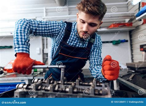 A Young Man Works At A Service Station The Mechanic Is Engaged In