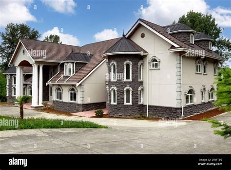 Luxury Home Exterior With Large Drive Way During Day Time Stock Photo