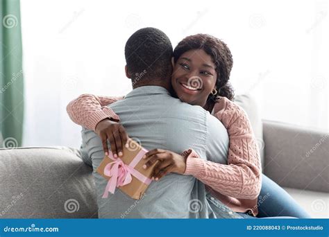Emotional African American Lady With Present Hugging Her Lover Stock