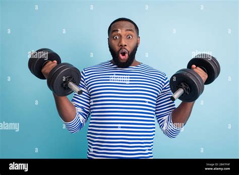Photo Of Handsome Dark Skin Guy Open Mouth Lifting Two Heavy Dumbbells