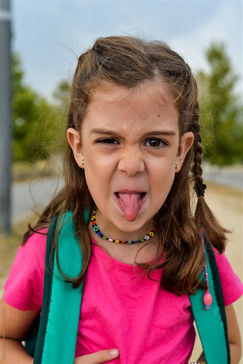 Little Girl Sticking Her Tongue Out After School By Stocksy