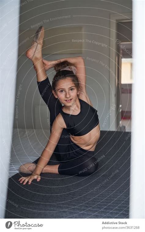 Flexible Acrobatic Girl Sitting On Bed A Royalty Free Stock Photo From Photocase