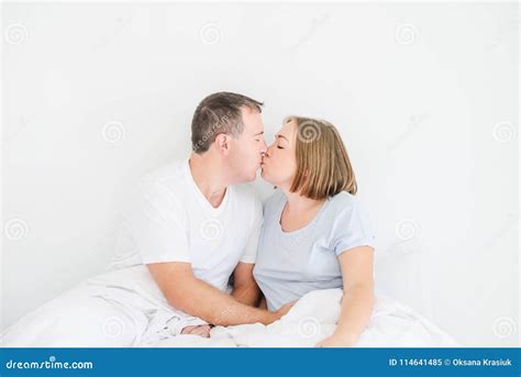 Küssen Von Netten Paaren Im Sleepwear Auf Dem Bett Ehemann Der Hand Auf Magen Seiner