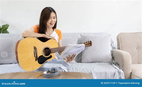 Woman Practicing Or Learning To Play Guitar And Practice Using His