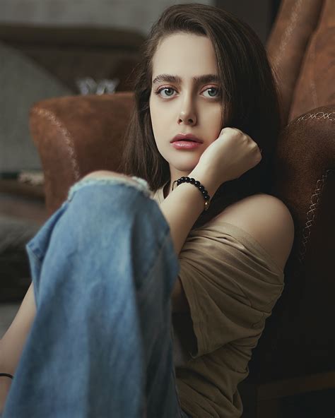 woman in black tank top and blue denim jeans sitting on brown leather couch photo free moscow